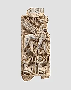 Furniture plaque carved in relief with a striding, falcon-headed winged sphinx supported by two kneeling figures