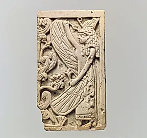 Furniture plaque carved in relief with a winged female figure and a “sacred tree”