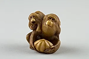 Netsuke of a Female Monkey Holding a Nut while her Baby Crawls on her Back by Masatami