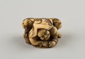 Netsuke of a Hunter Trying to Catch a Fox Beneath a Straw Hat