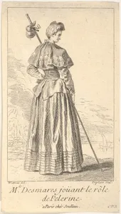 Actress Charlotte Desmares playing the role of a pilgrim, shown from behind with her head turned toward the right, she holds a walking stick, scallop shells adorn her cape