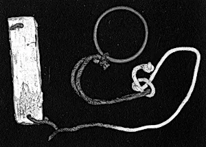 A plaque tied to a bracelet or ring with a cord