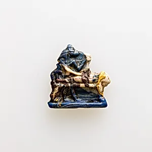 Amulet showing Anubis standing over mummy on bier