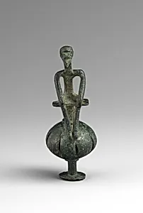 Bronze man seated on a ball