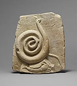 Fragmentary limestone relief with a snake and dolphin