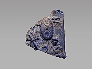 Glass plaque fragment depicting a trophy and captives