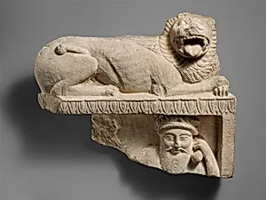 Limestone finial of a funerary stele with a recumbent lion and a banquet scene
