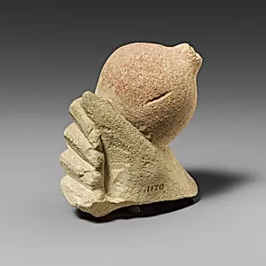 Limestone hand holding a pomegranate by Unknown Artist