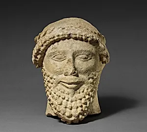Limestone head of a bearded male with a wreath of leaves