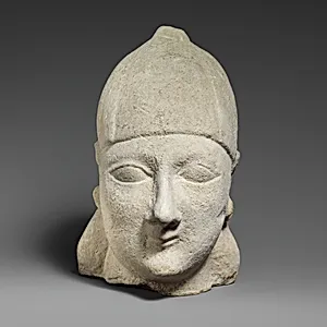 Limestone head of a beardless male wearing a conical helmet by Unknown Artist