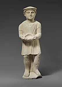 Limestone statuette of a boy with a kausia