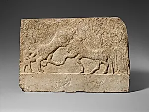 Limestone votive relief with a lion killing a bull and two human figures