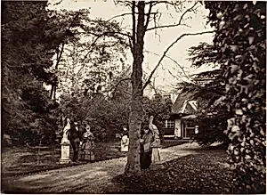 [Autumn Scene with People on Lawn near Cottage] by Unknown