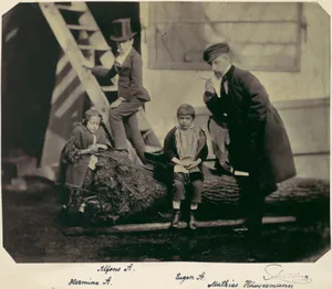 [Hermine, Alfons and Eugen Antoine and Mathias Häusermann on a fallen tree]