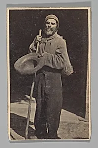 [Studio Portrait: Man with Walking Stick Begging (?)] by Le Vot