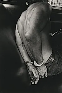A man taken into custody in a police car, New York City