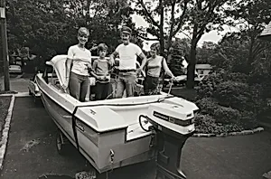 A police officer and family pose in their fishing boat, parked in their yard, Long Island, New York