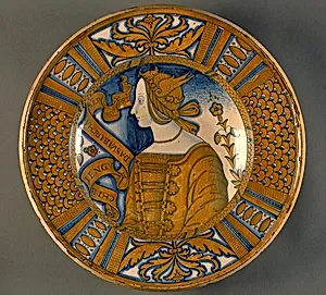 Large dish with segmental border of plant sprays and scale pattern; in the center, a profile bust of a woman in a winged headdress