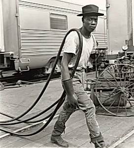 Railroad Passenger Car Maintenance Man. Air Hoses Were Used to Clean the Cars, Chicago, Illinois