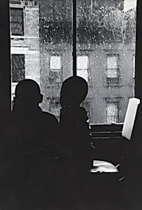 Two Boys Looking Out a Window on a Rainy Day
