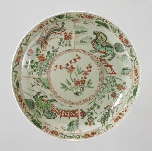 Saucer-dish with celadon glaze, prunus sprays, shishi, peacock and feng huangs by anonymous