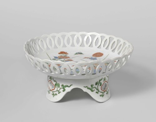 Saucer-dish on tripod with flowering plants near rocks by anonymous