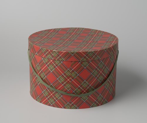 Ronde hoedendoos van karton, beplakt met geruit papier en voorzien van groene draagband by Maison de Bonneterie