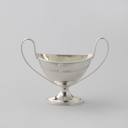 Suikervaas van zilver, ovaal op gewelfde voet en met twee hoge oren. Versierd met filetranden.