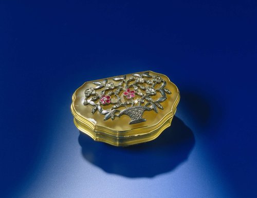 Snuifdoos van goud met deksel van chalcedoon. De geschulpte doos is versierd met een bloemenmand in reliëf van zilver, met diamanten en robijnen