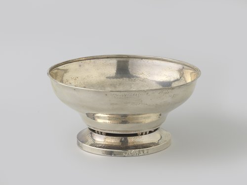 Vruchtenschaal van zilver, rond, met voet die van de schaal wordt gescheiden door drie maal vijf bollen.