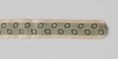 Lint of kousenband van zijde met lancé-effect; over de gehele lengte van het roze lint loopt een groene baan met een rasterpatroon waarin margrieten zijn verwerkt by anonymous