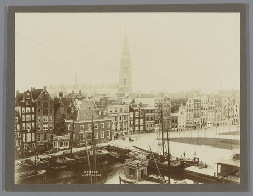 Gezicht op het Damrak met op de achtergrond de torens van de Oude Kerk en de Zuiderkerk te Amsterdam