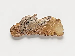 Pendant in the form of a dragon with dragon elements and raised uniform curls arranged in a grid, one of a pair by Unknown