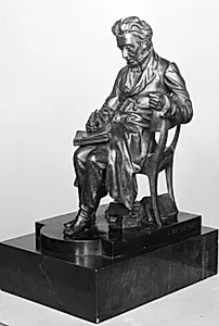 Forfatteren Søren Kierkegaard siddende i en stol, læsende i en bog by Louis Hasselriis