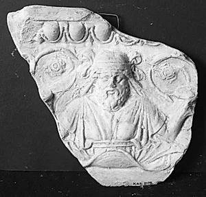 Hoved og overkrop af Dionysos, frontal, i begge hænder vinranke. Herover æggestav by Ubekendt