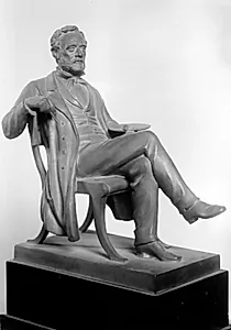 Maleren Wilhelm Marstrand siddende med en pensel og palet i en stol