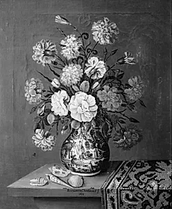 På et træbord, hvorpå der ligger et tyrkisk tæppe samt nogle konkylier står en blå porcelænskrukke med blomster by Margueritta Charbonnet