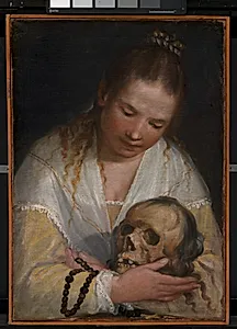 Ung kvinde som betragter et kranium